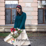 Stylish young woman with Christmas wreath outside, waiting for Christmas.