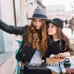 elegant-brown-haired-joyful-woman-felt-hat-making-selfie-with-charming-daughter-waiting-coffee-cafe